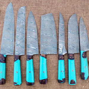 A 7-piece handmade Damascus steel kitchen knife set displayed on a textured background. The blades feature intricate wavy patterns and are paired with vibrant turquoise resin and dark wood hybrid handles. The set includes various shapes like a Cleaver, Chef’s Knife, and Paring Knife, shown alongside fresh green peppers and herbs.